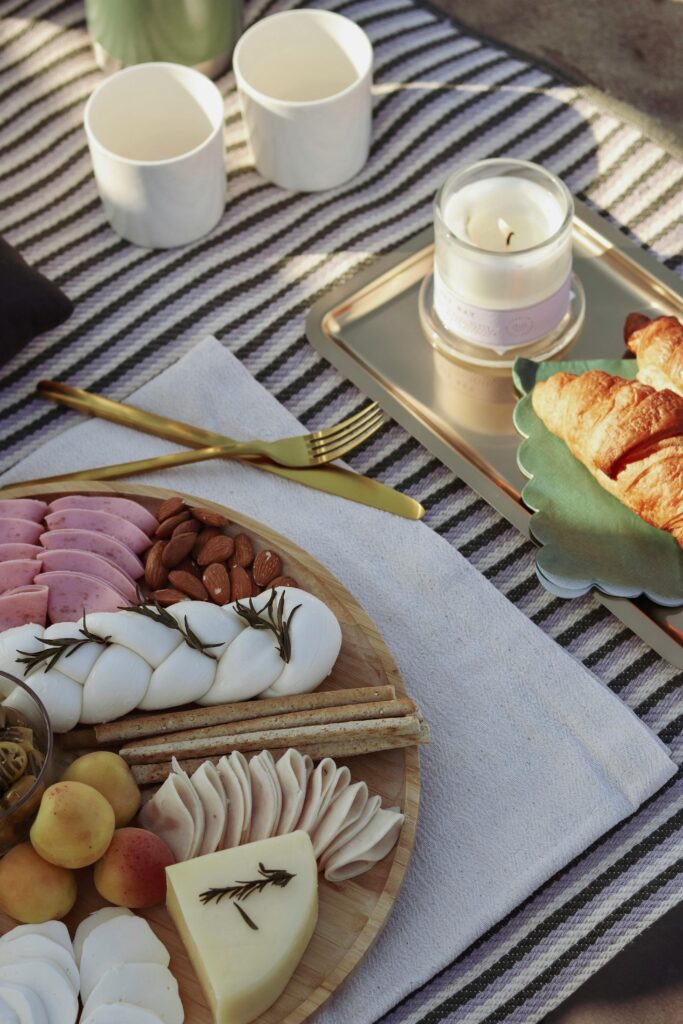 Charcuterie Board and Croissants on a Towel on a Beach